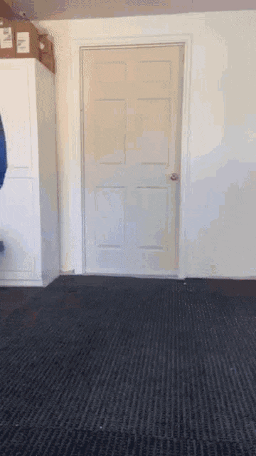 a door in a room with a black carpet and a box on top